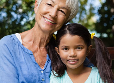 Grandmother hugging her young granddaughter